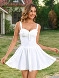 Woman smiling and twirling in a white fit and flare mini dress with spaghetti straps.