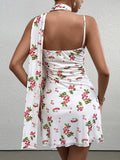 back view of a woman in a white sleeveless A-line dress with a red cherry print and a matching scarf