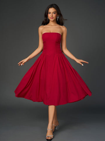 Woman wearing a red strapless midi dress with a ruched bodice and full skirt, posing with arms outstretched