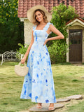 Woman wearing a light blue floral print maxi dress with ruffled shoulder straps and a square neckline, smiling and posing outdoors.