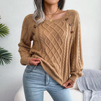 Woman in a tan cable knit sweater, showing the texture and fit.