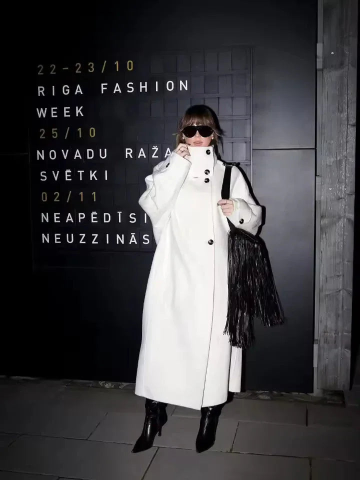 Side profile of a woman in a long white wool blend coat