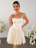Woman in a strapless ivory satin corset bodice mini dress with a flowing tulle skirt