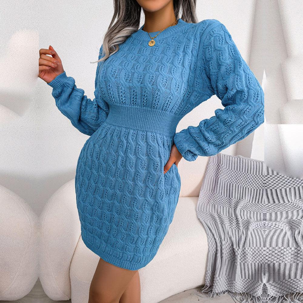 Woman wearing a blue long-sleeve knit sheath dress with a cable knit pattern and cinched waist.
