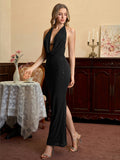 Woman posing in a black sparkly halter dress with a deep V-neck