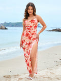 Woman standing on a beach wearing a pink floral print maxi dress with a high slit
