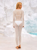 Back view of a woman in a white crochet knit maxi dress, showing the open knit pattern.