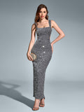 Woman in a form-fitting silver sequined evening gown with a square neckline, standing with hands on hips against a grey backdrop.