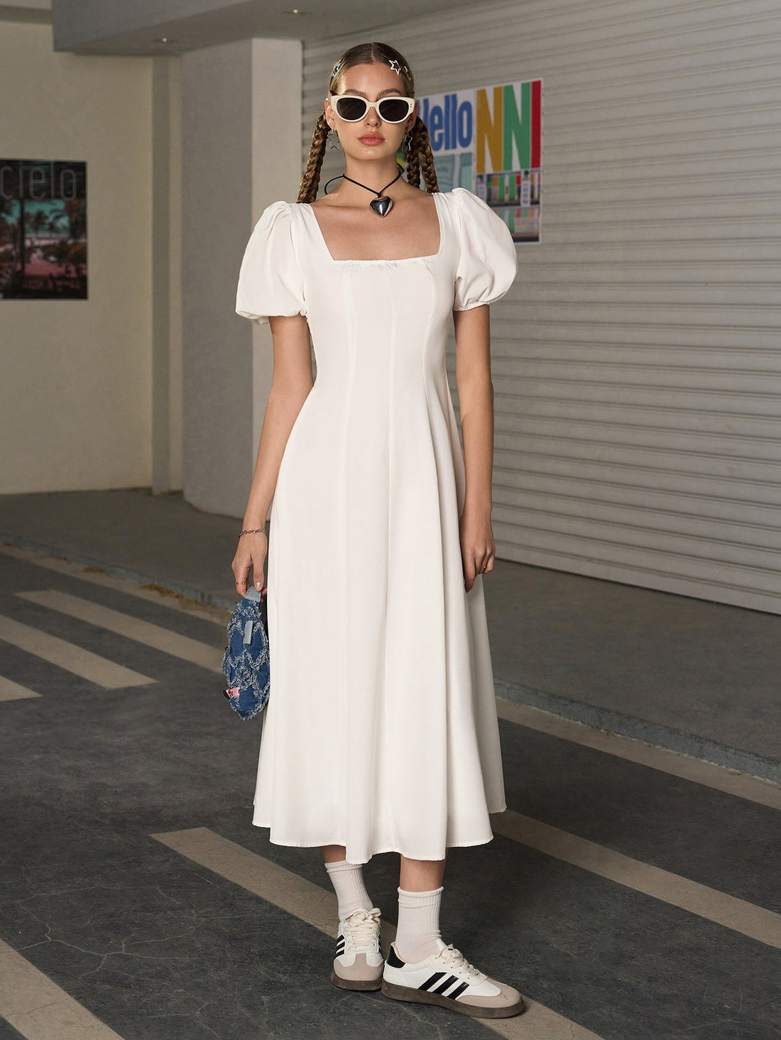 Woman wearing a white square neck puff sleeve midi dress.