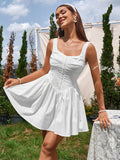 Woman wearing a white sleeveless ruched bodice dress with a gathered skirt and square neckline, holding her hand near a table outdoors.