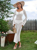 Woman wearing a white long-sleeve crochet maxi dress cover-up, a wide-brim hat, and carrying a straw handbag, front view.