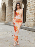 Front view of a woman showcasing a fitted, floral print maxi dress with a square neckline and spaghetti straps.