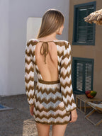 Back view of a woman in a knit cover-up dress with an open back and tie detail