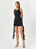 Full body shot of a woman in a black sleeveless bodycon mini dress with ruffle details.