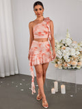 Model showcasing a fashionable pink tie-dye outfit with a one-shoulder top and a ruffled skirt.