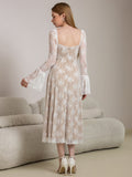 Back view of a woman in a white lace midi dress with bell sleeves.