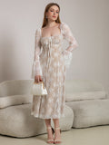 Woman wearing a white lace midi dress with bell sleeves and a tie-front detail.