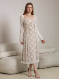 Model posing in a white lace midi dress with bell sleeves and a tie-front detail.