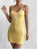 Close-up of the bust detail on a yellow knit bodycon mini dress.