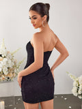 Back view of a woman in a black strapless sparkle mini dress