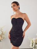 Woman in a black strapless sparkle mini dress with long dangle earrings