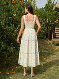 Woman in a straw hat wearing a yellow floral print midi dress and holding a basket of fruit, standing in an orchard.