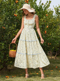 Close-up of the smocked bodice and tie front detail on a yellow floral print midi dress.