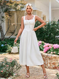 woman posing with hand on hip in a white sleeveless midi dress in a garden