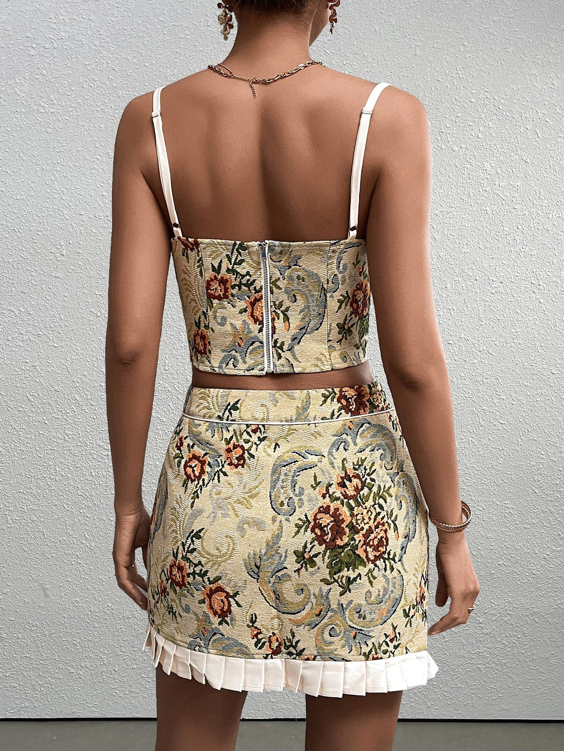 Woman wearing a yellow floral brocade cropped camisole with white trim and tie front.