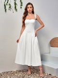 Full body shot of a woman modeling a white smocked bodice midi dress with tie shoulder straps