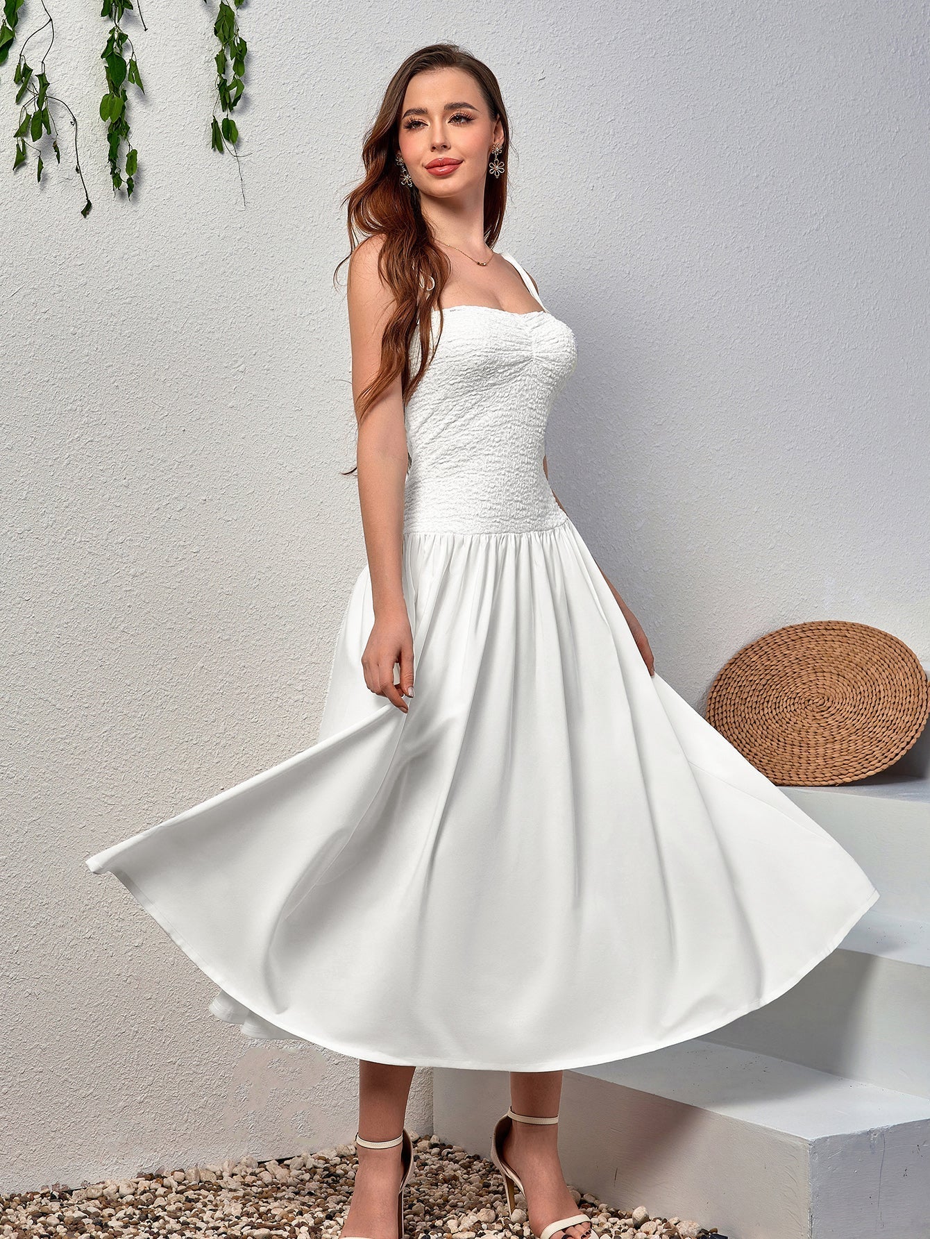 Woman wearing a white midi dress with a smocked bodice and a flowing skirt