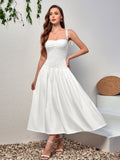 Woman in a white midi dress with a gathered skirt and smocked bodice, with her hand on her hip
