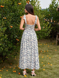 Back view of a woman in a floral print midi dress with a corset bodice and tie shoulder straps.