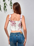 Back view of a woman in a white and red toile print corset top with a zipper closure and blue jeans