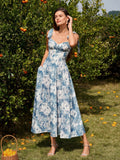 Woman in a blue and white floral print midi dress with pockets, posing in an orchard.