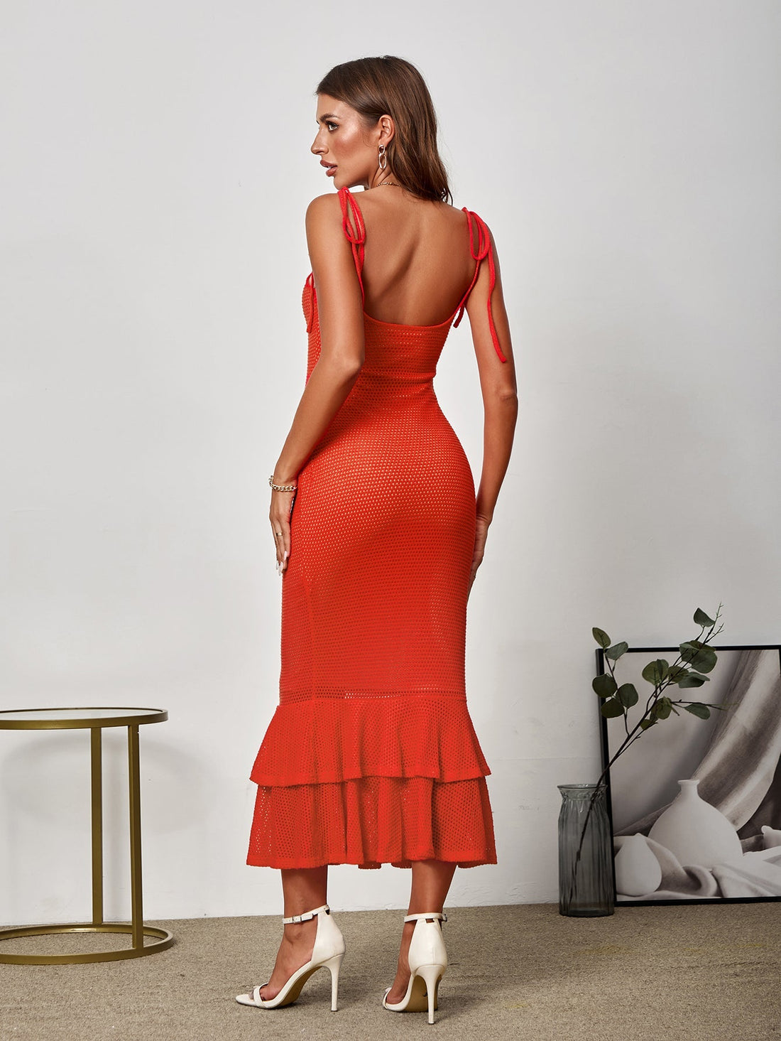 woman in orange textured knit mermaid dress with tie straps and tiered ruffle hem