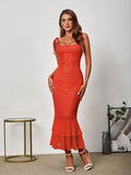 woman in orange textured knit mermaid dress with tie straps and tiered ruffle hem