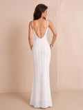 Back view of a woman in a white mermaid dress with a low back and spaghetti straps.