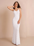 Woman posing in a white textured mermaid dress with a v-neckline and spaghetti straps.