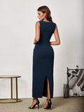 Back view of a woman in a navy blue sleeveless V-neck maxi sheath dress with button detailing and a side slit.