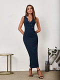 Woman with hands behind her back wearing a navy blue sleeveless V-neck maxi sheath dress with button detailing and a side slit.