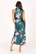 Back view of a woman in a green satin midi dress with a pink floral print and halter neckline.