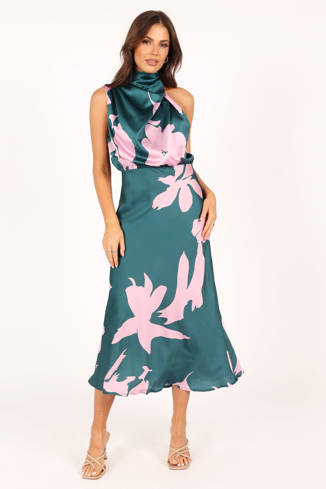 Woman wearing a green satin midi dress with a pink floral print and a halter neckline.