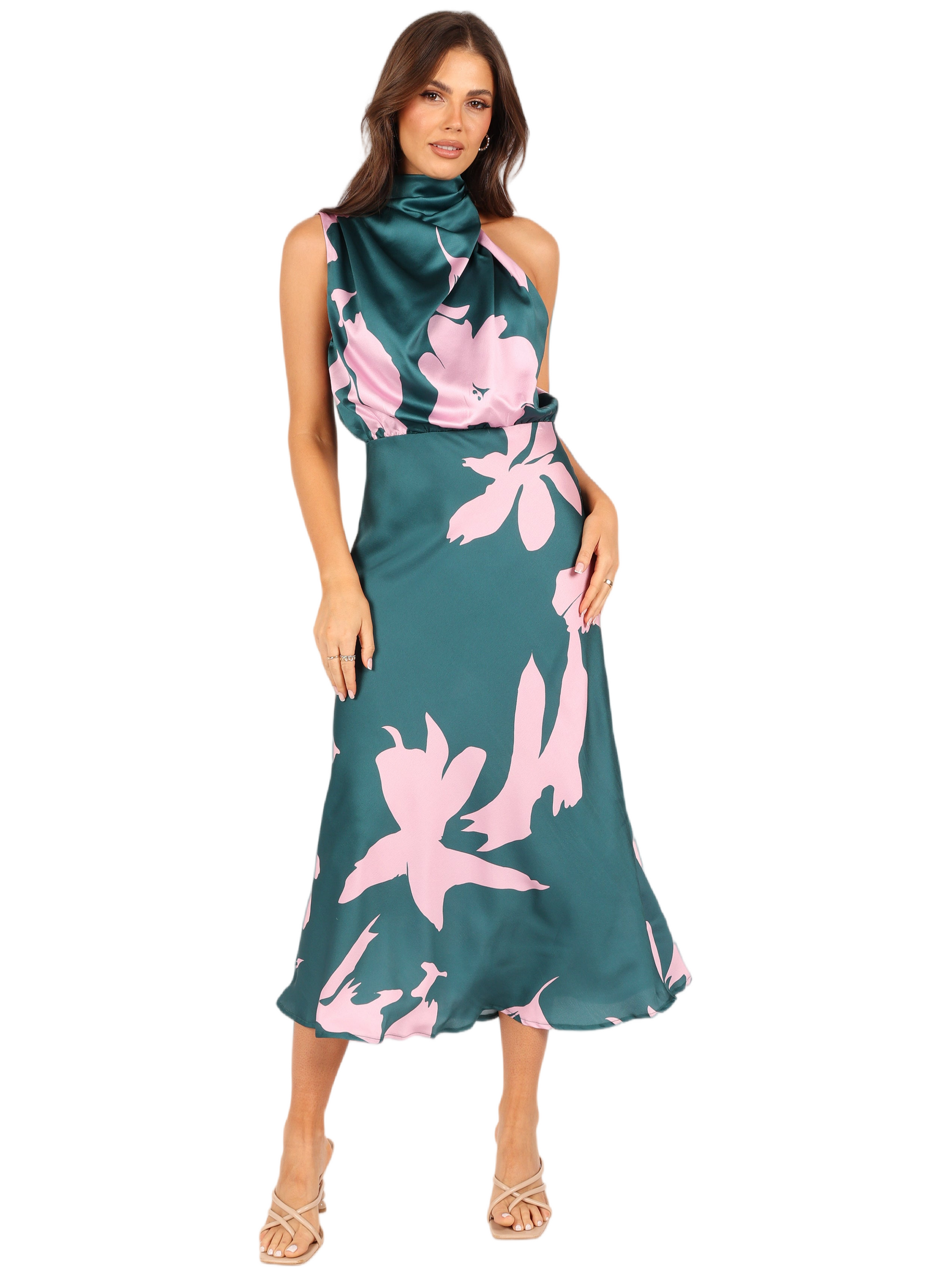 Woman wearing a green satin midi dress with a pink floral print and a halter neckline.