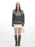 Woman wearing a grey Fair Isle crewneck sweater with a cream beanie and skirt