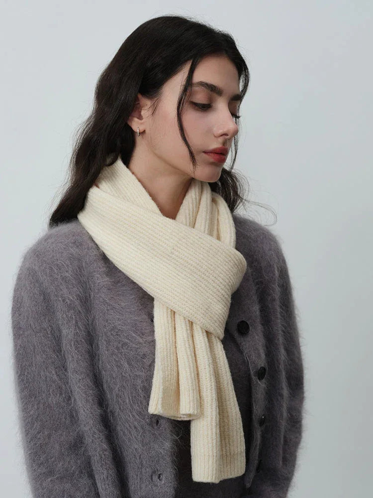 Woman wearing a cream-colored ribbed knit scarf