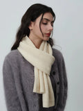 Close-up of a woman wearing a cream-colored ribbed knit scarf around her neck
