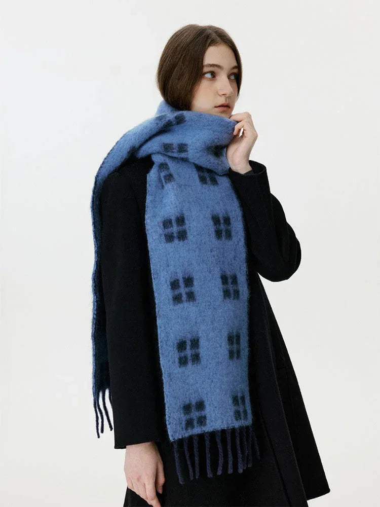 Side profile of a woman wearing a blue scarf with a black windowpane plaid pattern
