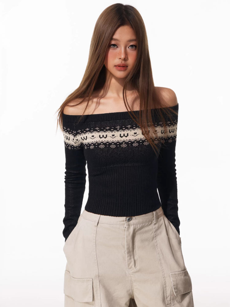 Close-up of a woman's upper body wearing a black off-the-shoulder sweater with a patterned design.