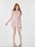 Woman modeling a pink bow-front dress with ruffled cap sleeves
